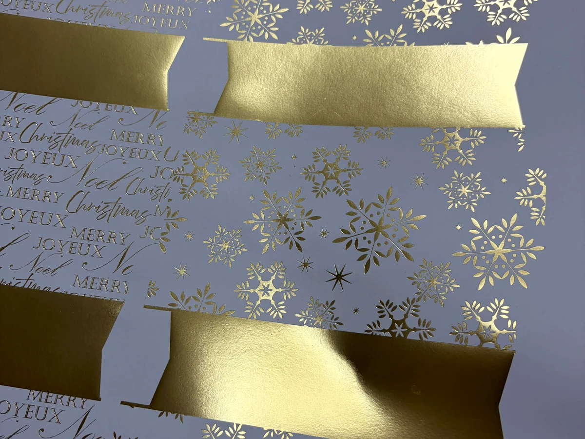 Gold foil Christmas cracker material samples under light