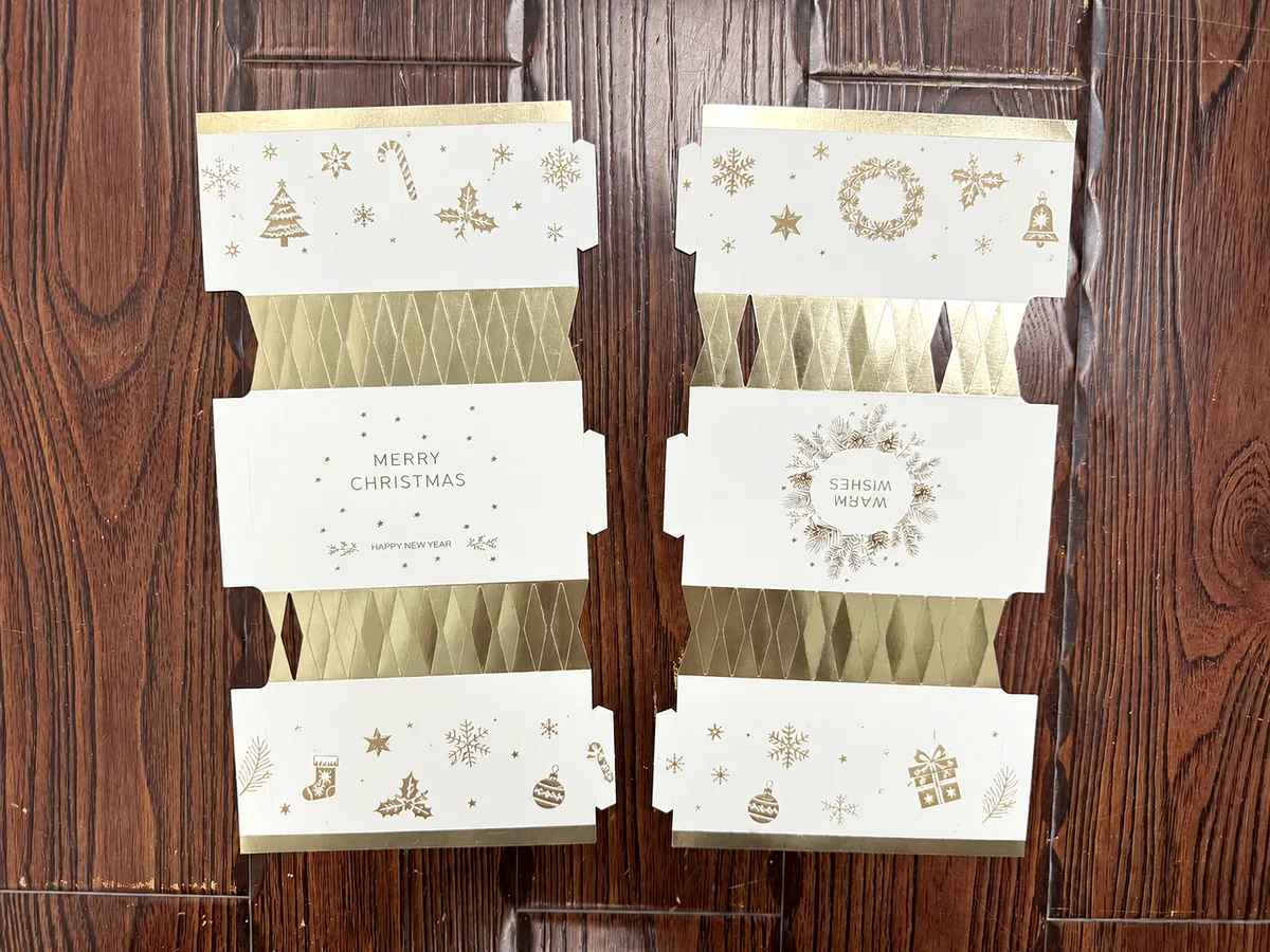 White and gold Christmas cracker paper structures laid out for material and print review