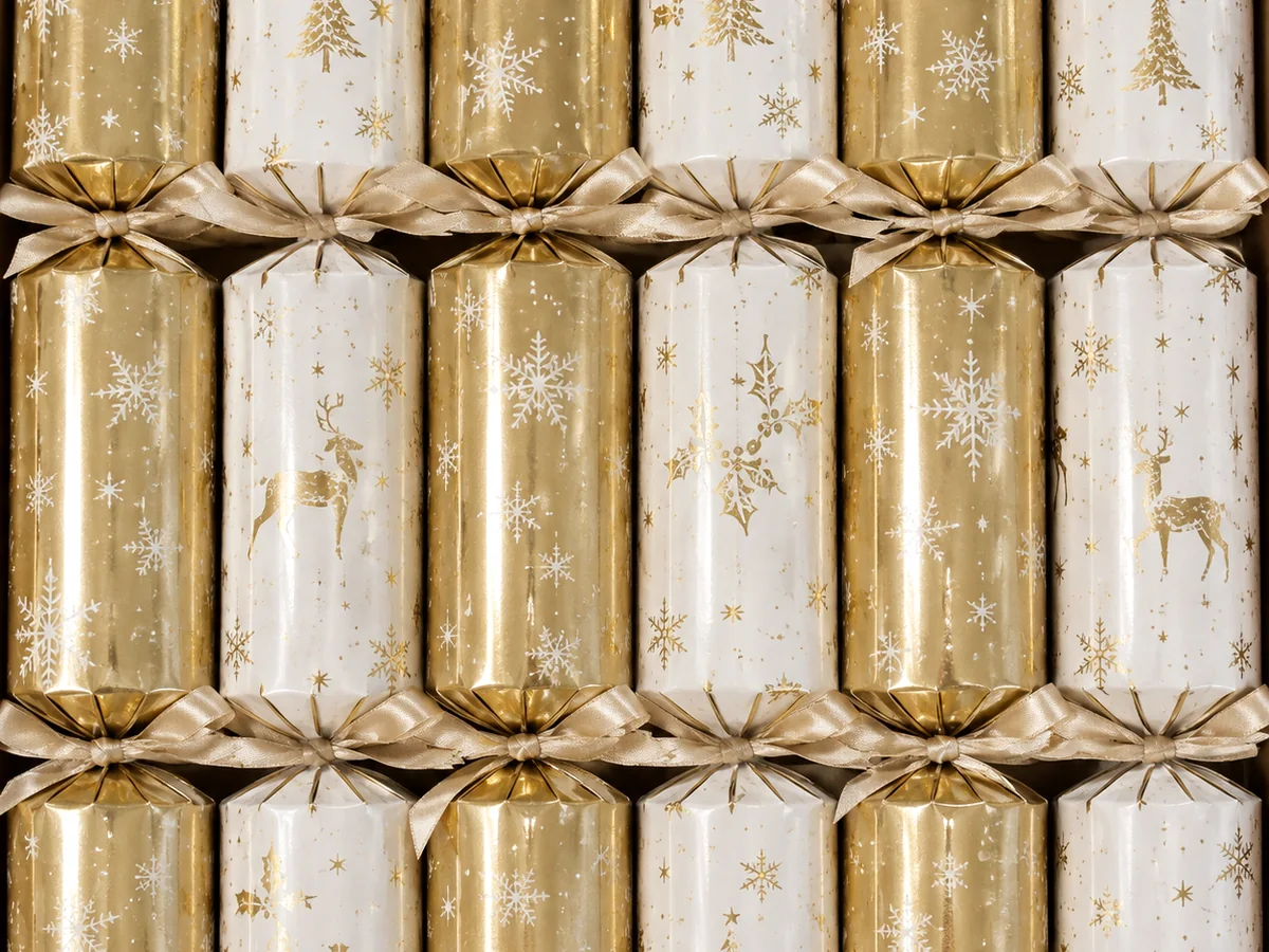 Gold and ivory Christmas crackers with festive printed motifs